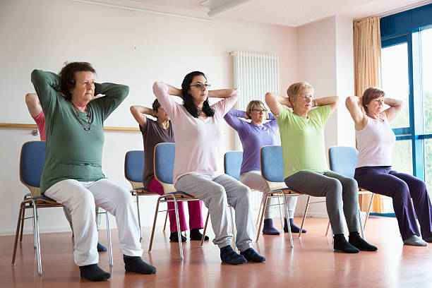senior women exercising yoga and pilates sitting on chairs